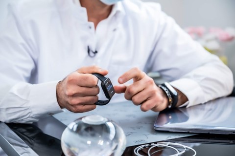 An allurion patient with a balloon is checking his weight loss progress on his Allurion watch